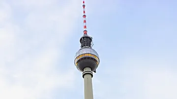 Television tower in Berlin rises into the sky under blue skies.