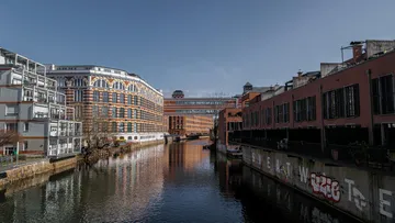 Moderne Gebäude spiegeln sich im ruhigen Kanalwasser.