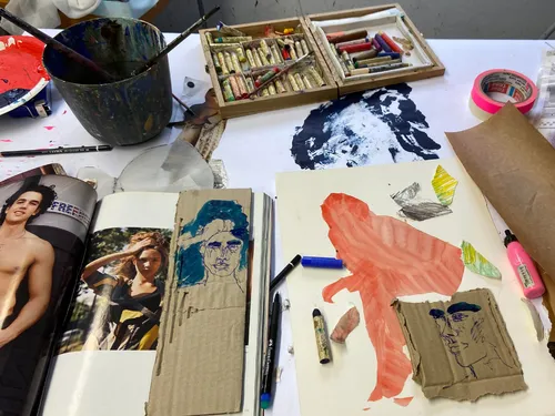 Art materials lie on a table, drawings are created.