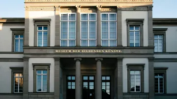 Museum shows elegant façade with large windows, central.