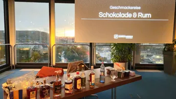 Table with chocolate and rum in front of windows with a view.