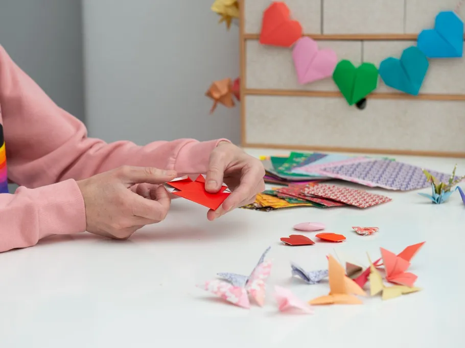 Red origami hearts are folded on a table.