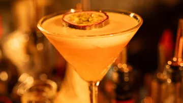 Cocktail in einem Glas, dekoriert mit einer Fruchtscheibe.