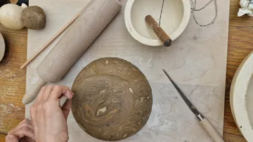 Tonplatte wird bearbeitet, um ein Kunstwerk zu schaffen.