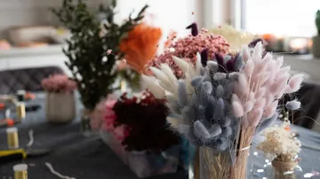 Dried flower arrangements are placed on a table in a room.