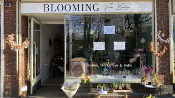 Blumenladen zeigt Angebote und Dekoration im Schaufenster.