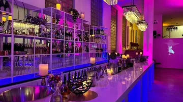 A stylish bar with colorful lights and glasses.