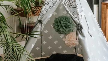 There is a pitcher tent with decorations in a living room.
