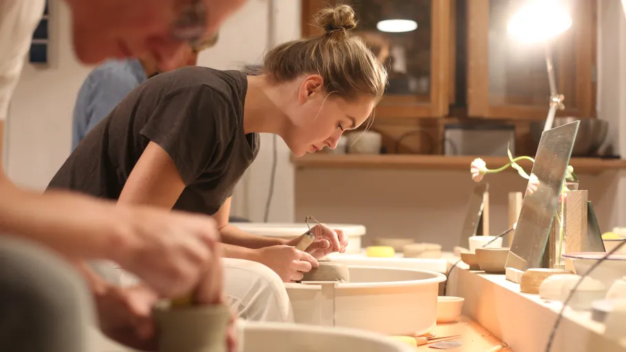 Töpferinnen formen Keramik in einem hellen Atelier.