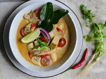 Ein Teller mit cremiger Suppe, gefüllt mit Huhn und Gemüse.