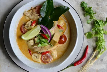 Ein Teller mit cremiger Suppe, gefüllt mit Huhn und Gemüse.