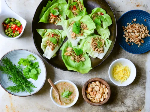 Salatblätter mit Hackfleischfülle und frischen Zutaten angerichtet.