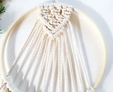 A macrame circle with a braided pattern hangs decoratively.