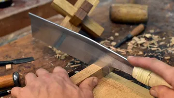Wood tools cut a piece of wood on a workbench.