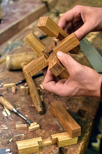 Holzstücke werden zu einer Struktur montiert, Werkstattumgebung.