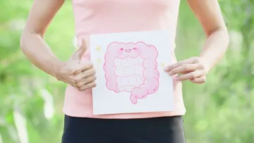 Eine Person zeigt ein Bild eines glücklichen Darms.
