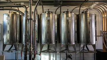 Stainless steel tanks stand side by side in a modern room.
