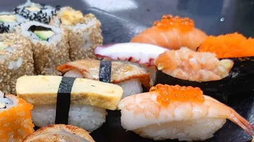 Sushi plate shows various sushi rolls and nigiri.