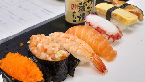 Sushi auf einem Teller, kreativ angeordnet mit Sojasauce.