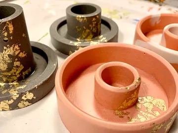 Colourful candle holders stand on a table with decoration.