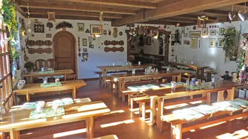 There are wooden chairs and tables in a cozy restaurant.