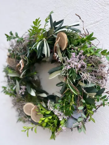 Grüner Laubkranz auf weißer Wand.