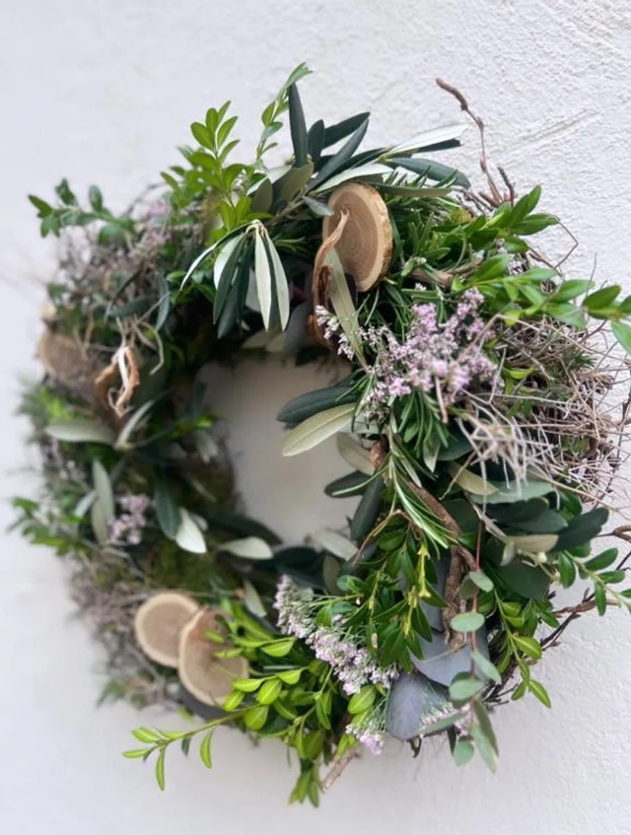 Green foliage wreath on white wall.