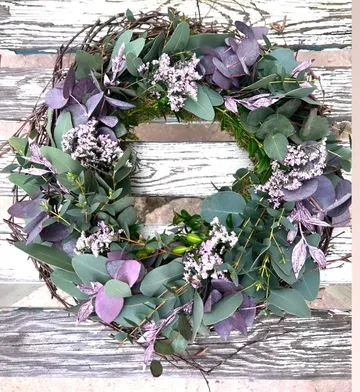 Blumenkranz liegt auf einer holzverzierten Oberfläche.