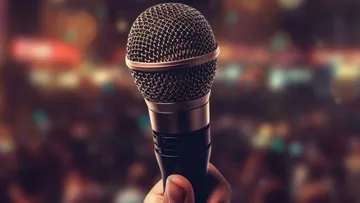Mic in hand, ready for performance, blurred background