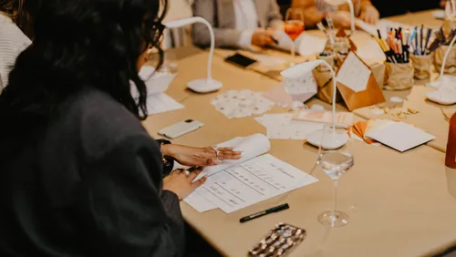 A person flips through documents at a table.