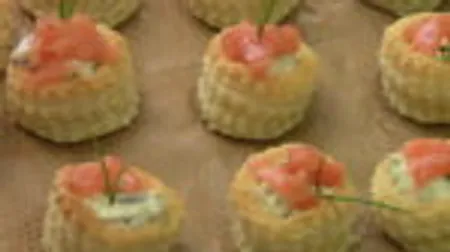 Small bites of salmon and herbs on a tray.