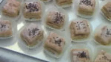 Small, decorated pastries lie on a tray.
