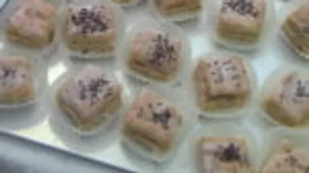 Small, decorated pastries lie on a tray.