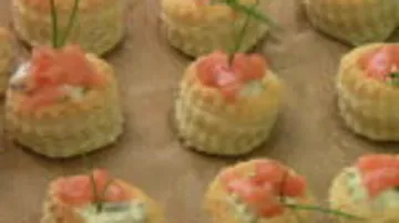Kleine Häppchen mit Lachs und Frischkäse auf platter Basis.