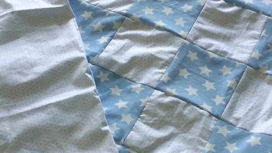 Decke aus blauem und weißem Stoff mit Sternenmustern.