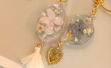 A piece of jewelry with dried flowers and gold accents.