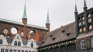 Zwei verschiedene historische Gebäude mit Türmen und Fenstern.