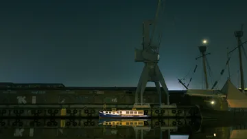 A boat is quietly lying in the harbor, illuminated by light.