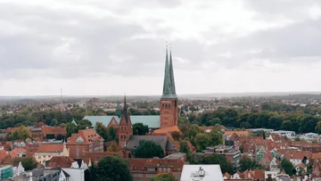Hochhäuser mit Türmen stehen über einer Stadtlandschaft.