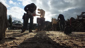 Woodworkers carve figurines in a sunny environment.