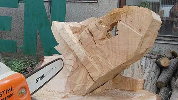 A block of wood is processed with a chainsaw.