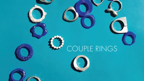 Paare Ringe liegen verstreut auf blauer Oberfläche.