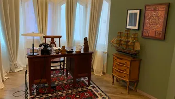 A desk is in a bright, cozy room.