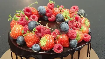 Chocolate cake decorated with fresh berries and fruits.
