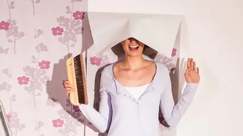 Frau hat Spass am Tapezieren