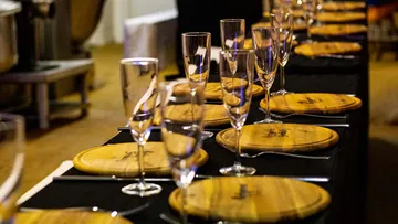 Wooden plates and glasses are elegantly arranged on a table.