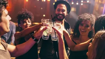 Gläser werden angehoben, während Freunde feiern und lachen.