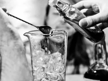 A glass of ice is filled with a liquid.