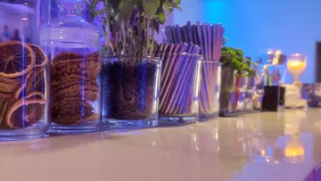 Glasses with snacks and straws on a table.