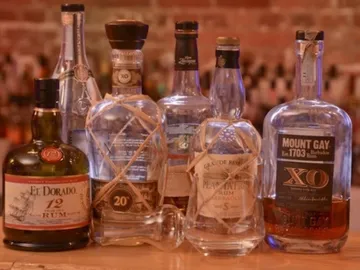 Various bottles of rum stand on a wooden surface.